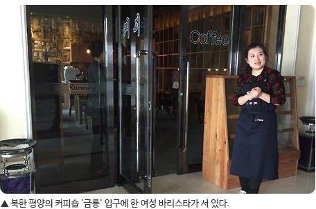 북한 평양의 커피숍 '금릉' 입구에 한 여성 바리스타가 서 있다.
