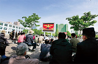 5월 8일 평양역 주변에서 전광판 TV로 노동당 7차 대회를 시청하는 평양 시민들. 많은 관심에도 불구하고 이들은 장밋빛 미래를 듣지 못했다. 김정은은 이렇다 할 경제정책을 내놓지 못한 것이다. 
