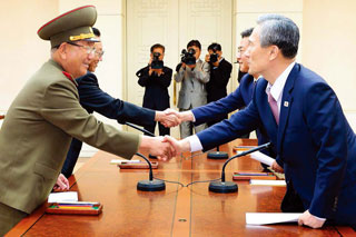 지난해 8·25 합의 직후의 남북 대표들. 김관진 국가안보실장(오른쪽)이 황병서 북한군 총정치국장과 악수하고 있다. 그 뒤는 홍용표 통일부 장관과 지난해 12월 교통사고로 사망한 김양건 북한 노동당 비서. (사진제공 · 통일부)