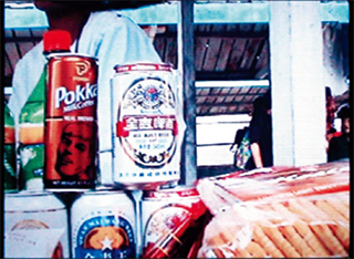 2003년 피랍탈북인권연대가 비디어로 찍어온 장소 미상의 북한 장마당. 쌀과 싱가포르 포카(Pokka)사가 만든 과일음료 캔, 중국 맥주 등이 거래되고 있다. 배급 붕괴가 생필품이 유통되는 시장을 활성화시켰다.